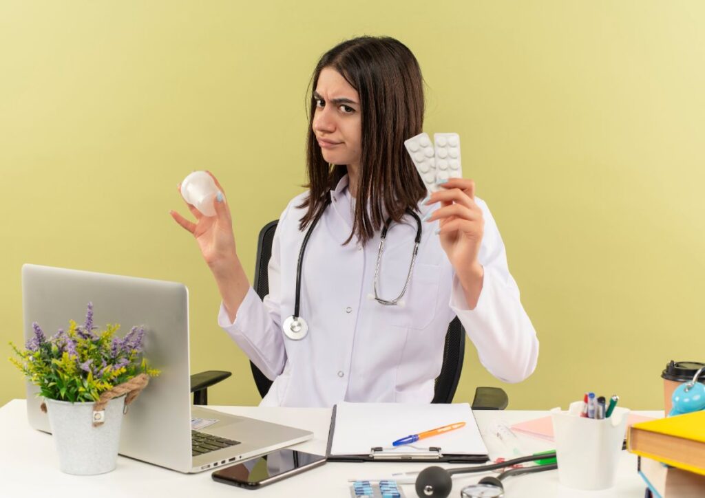 A doctor holding blister packs of vitamins, expressing curiosity, illustrating the question: How long does it take for vitamins to work?