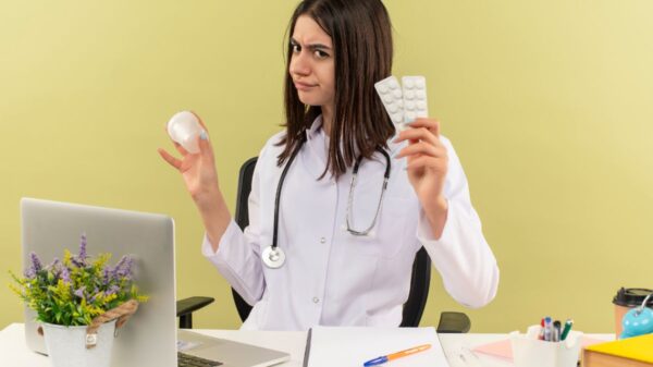 A doctor holding blister packs of vitamins, expressing curiosity, illustrating the question: How long does it take for vitamins to work?