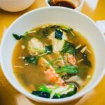 A bowl of miso soup with seaweed, tofu, and green onions, answering the question: is miso soup vegan?