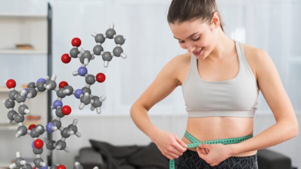 Smiling woman measuring her waist with a tape measure, showcasing the effectiveness of peptides for weight loss.