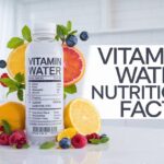 Vitamin Water Nutrition Facts A bottle of Vitamin Water surrounded by fresh fruits like orange slices, raspberries, blackberries, and lemon, with the text "Vitamin Water" in stylish font on the right.