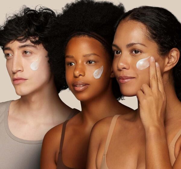 Three Diverse Individuals Applying Facial Moisturizer On Their Cheeks.