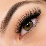 Eyelash Extension Styles: How to Choose the Perfect Lash Look for Your Eye Shape 7 An Extreme Close-Up Of A Woman'S Hazel Eye Showcasing A Dramatic, Full-Volume Eyelash Extension Style With Long, Thick, Dark, And Perfectly Fanned Lashes That Frame The Eye Beautifully, Demonstrating The Transformative Impact Of Professional Eyelash Extension Styles On Natural Eye Beauty.