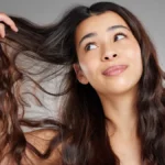 The Complete Hair Care Guide: Build a Routine That Actually Works for Your Hair Type 4 Woman Examining Wavy Hair Hair Care Tips