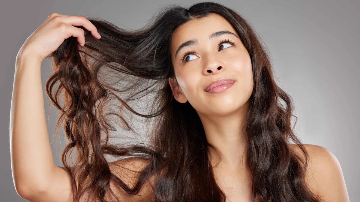 Woman Examining Wavy Hair Hair Care Tips
