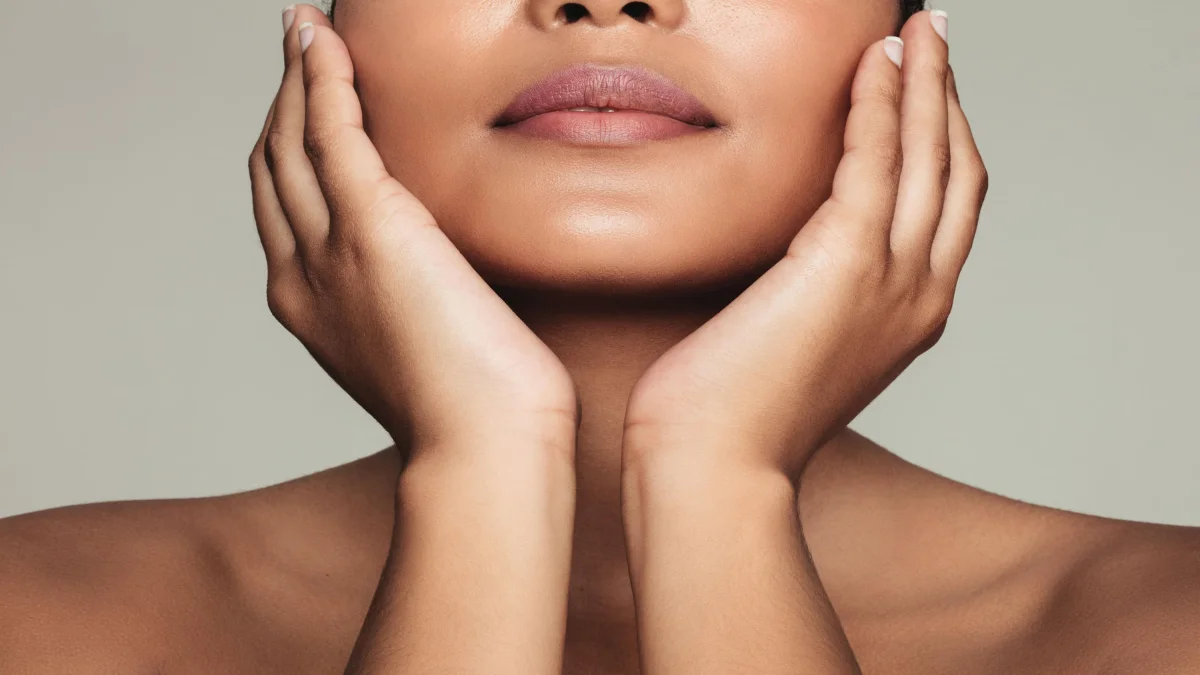 How to Revive Dull Skin: A Step-by-Step Guide to Restoring Your Natural Glow 4 A Close-Up Of A Model Gently Cradling Her Smooth, Glowing Jawline, Illustrating How To Treat And Brighten Dry Or Dull Skin With Proper Hydration.